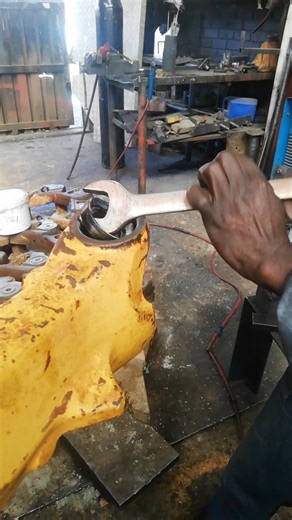 USING SPANNERS TO REMOVE WORN BUSH FROM TRACTOR'S AXLE PRIOR FITTING PINION AND RESPRAY