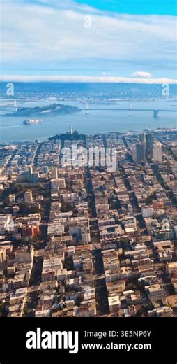 City street grid, Coit Tower, and the San Francisco Oakland Bay Bridge over water. Aerial view of San Francisco grid. Vertical video Stock Video Footage - Alamy