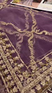 Step into a world of opulence with this enchanting couture ensemble by Honey Waqar. Drenched in majestic hues of soft emerald and royal amethyst, this flared silhouette is a true celebration of craftsmanship and heritage. Intricately adorned with hand-embellished silver zari, tilla, and sequins, the design evokes an aura of timeless royalty. The bodice features a delicately structured neckline with elaborately detailed sleeves, cascading into a voluminous kalidaar that tells a story in every mot