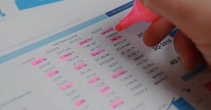 Financial Report Being Highlighted With a Pink Marker