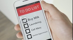 Using a To Do list app on a smartphone. Checking the tasks one by one.
