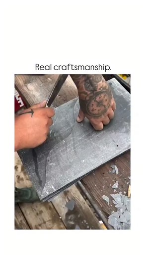 spidey 🕷️ on Instagram: "The post showcases a 43-second video of a skilled roofer hand-cutting slate tiles with a hammer and chisel on a weathered board, then precisely fitting and nailing them onto blue underlayment to form a seamless, overlapping fish-scale roof pattern. This exemplifies traditional slate roofing craftsmanship, where "head lap" technique-overlapping tiles by at least 3 inches-prevents water infiltration, enabling roofs to last 100-200 years, per the North American Slate Assoc