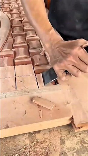 carving wood with a chisel to create square patterns for a decorative door panel design today
