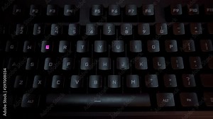 The word women is typed on a luminous computer keyboard. Black backlit keyboard with letters. The keyboard itself prints the word using the backlight.