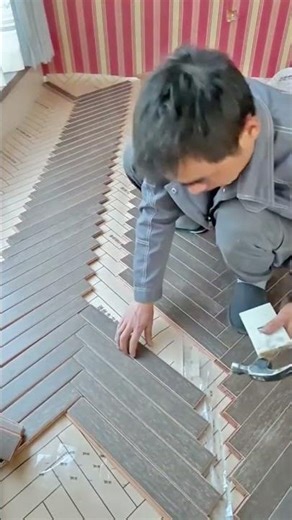 Skilled installation of dark wood flooring in a beautiful herringbone pattern