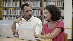 Slow motion shot of two people talking at library Free Stock Video Footage