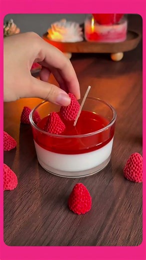 Creating decorative glass candle variations featuring miniature artificial strawberries.