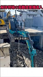 A high-skill excavator operation unfolds at a building demolition site.