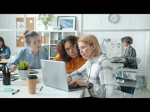 Group of office workers serious females using laptops typing and talking discussing work