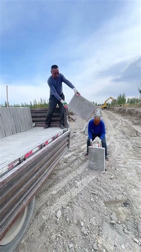 Manual Labor: Unloading Heavy Concrete Slabs from a Truck