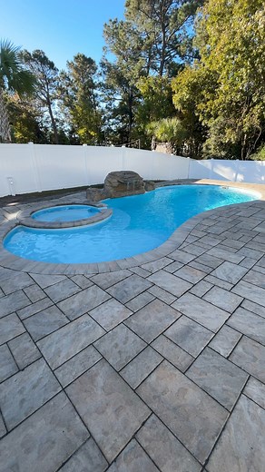 I30S in Summerhouse with a rock water feature paired with Techo-Bloc Blu60 Slate and Bullnose Coping! #swimmingpool #summerhouse #FiberglassPools | Pools, Patios, and Spas LLC
