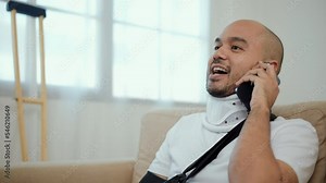 Man recovery from accident fracture broken bone injury with leg splints in cast, neck splints collar, arm splints, sling support arm using smartphone. Social security and health insurance concept.