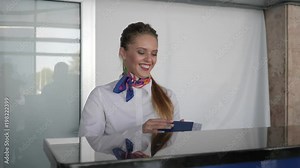female airport staff in uniform checking tickets and passport of commuters at check-in desk at aeroport