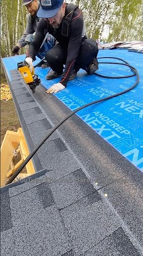 Laying The First Row of Flexible Shingles on The Roof of a Frame House