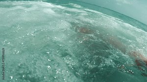 Handsome man swims azure tropical sea films himself on camera sea wave covers him with strength. Sea wave suddenly hits bringing pleasure and fun Sea wave is indispensable part of relaxing on beach.