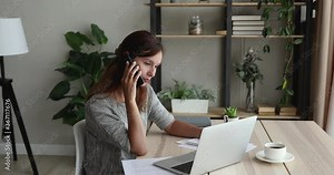 Telework, administrative, clerical work concept. Businesswoman sit at desk talk on phone provide support to client, solving working moments, smile enjoy distant conversation using laptop writing notes