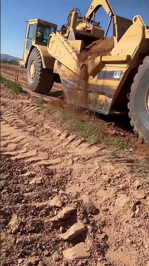 631 scraper dumping on pad #constructionequipment #caterpillar