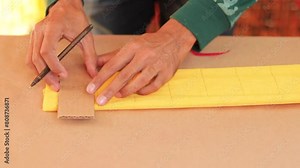 Artisan drawing lines on crepe paper and cutting it with scissors for decorations