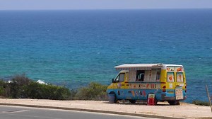 Ice cream bus on the beach. Color bus with ice cream near the sea on a hot day