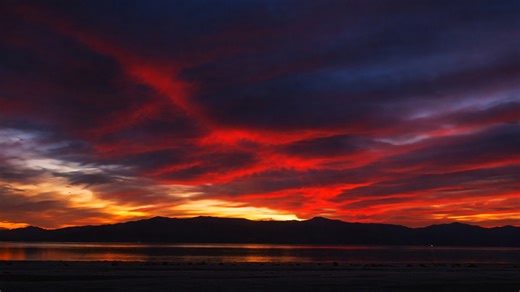 Burning sky casting warm light over still waters
