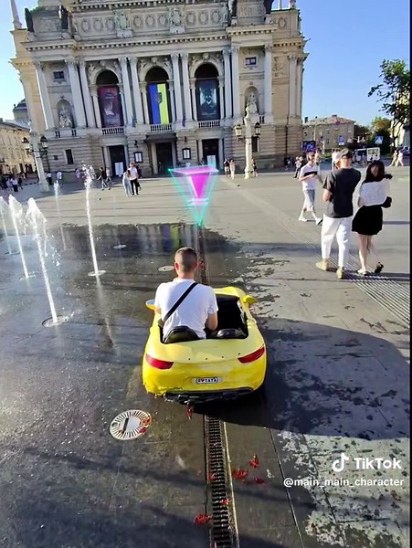 Bright Yellow Convertible Car Driving Through Public Square