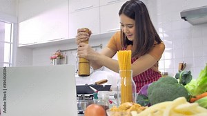 Young Asian woman cooking in kitchen at home.