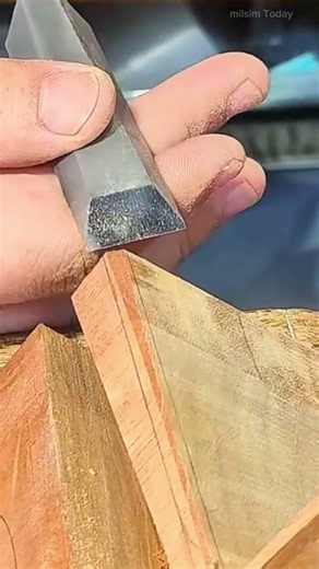 Shaping and smoothing the edge of a joint on a wooden piece using a sharp hand chisel tool expertly