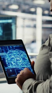 Vertical Close up of data center system administrators deploying deep learning software on rigs. Team of server hub IT experts train AI systems with datasets using tablet to support applications, camera B