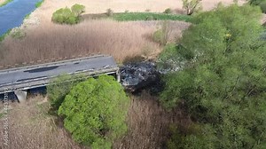 Traffic collapse. Road construction site, broken asphalt, pieces bitumen layer road surface from demolition road in sunset. Excavator hydraulic crushes concrete slabs. Heavy construction equipment.