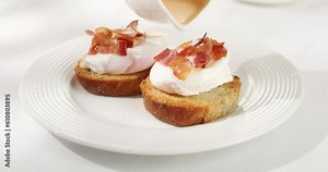 poached egg toast topped with hollandaise sauce. benedict egg. serving breakfast on a white background. sunny day. angle view. smooth zoom camera movement.