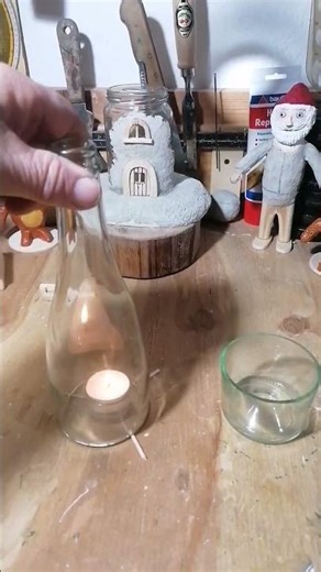 Eine abgeschnittene Weinflasche und ein Teelicht.