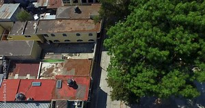 Drone shot slowly lowering over Guatemalan road and person on crutches