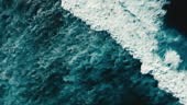 Top down aerial birds eye view shot of tropical blue ocean waves...