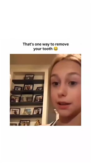 Kryth | Trend Theory on Instagram: "The video features a young blonde girl sitting in a cozy living room filled with framed family photos on shelves in the background. She opens her mouth wide, pointing to a loose tooth in her upper jaw, seemingly preparing for an unconventional extraction. A white cockatoo parrot is introduced, perching nearby as someone off-camera guides it toward her. The bird curiously approaches, its beak gently probing her open mouth, building anticipation in this quirky, 