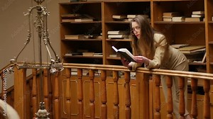 Beautiful young woman in suit and glasses spending time in the old vintage library reading book Stock Video