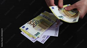 Hands counts different European money banknotes one on top of the other. 500 Euro banknote counting.
