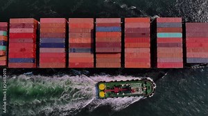 Container cargo ship and transportation, Business International trade and Container logistics export-import harbor to the International port / Cargo ship passing the harbor - Top view from drone
