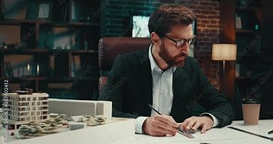 Man architect drawing blueprints of a building while working in the office