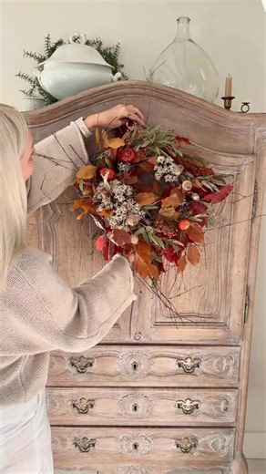 Ad| How gorgeous is this handcrafted wreath of crimson leaves, ruby berries, & tiny pumpkins from @wild.flowersonline It looks so perfect draped over our antique armoire! 🍁🌿🤎 Happy fizz Friday all, love A xx #AutumnWhimsy #cosyseason #AutumnMagic #FallDecor” #seasonalwreaths | Shutters and Stone