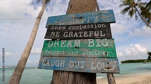 Close-Up Slow Motion Shot Of Wooden Signboards On Coconut Palm Tree Trunk At Beach - Thulusdhoo, Maldives
