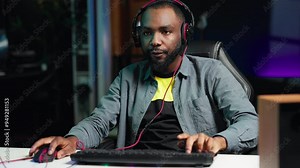 Gamer feeling relieved after winning videogame level, screaming at computer in excitement. Pleased man at home yelling from joy after seeing achieving victory while playing on gaming PC, camera A