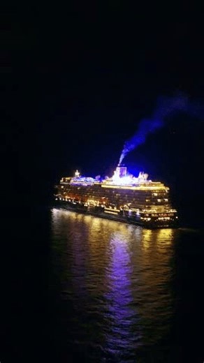 Cruise ship at night sailing through dark waters. Vertical video