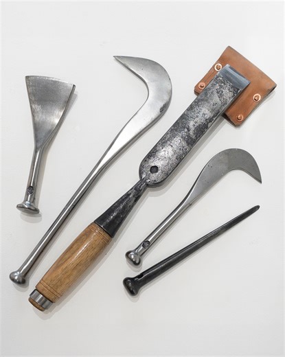 Happy Halloween! In light of the coming holiday, these tools might look ominous and sinister, yet while their sharp blades and points could be painful, they are actually very traditional tools for the long held and benign craft of boat building. Med Chandler’s work at Ship’s Coy Forge is rooted in the belief that mastering traditional blacksmithing techniques—hammer, anvil, and careful study of original tools—produces tools and ironwork that will endure for generations. While he makes use of mod