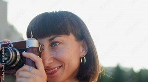 young girl with a camera. Fashionable and attractive beautiful woman with analog film camera takes photos during sunset, creates content. travel and vacation.