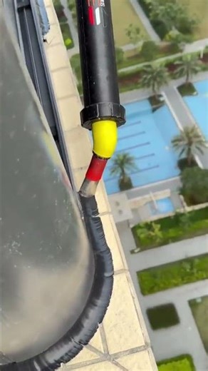 the process of applying black cream to the corners of windows outside a multi-storey building #short