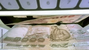 Electronic money counter machine is counting Thai baht THB