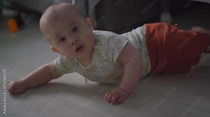Baby exploring all around the house, 7 month old baby boy crawling, touching everything. Baby learning to crawl and play on the floor with a toys.