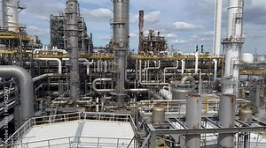 Panorama inside of the interior of a chemical plant or oil refinery. Pipeline structure, heavy equipment in process area. Steel tanks and boilers with cables, pipelines and valves for chemical mixing