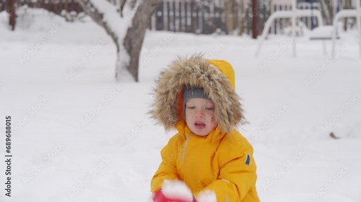 Toddler child removing snow with shovel little boy clearing path and shoveling snow in the yard. Winter kids fun outdoor.