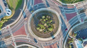 Traffic circle on american road with driving cars. Overhead view of US roundabout intersection